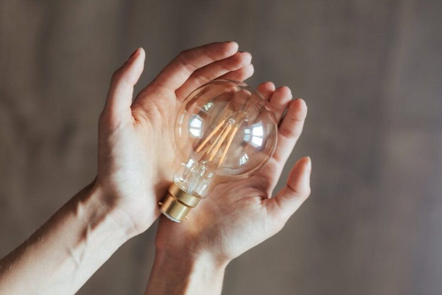 unrecognizable woman demonstrating light bulb in hands